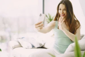Mujer sonriendo durante una videollamada en casa