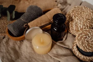 Aceite de masaje, vela y toalla sobre una superficie de madera